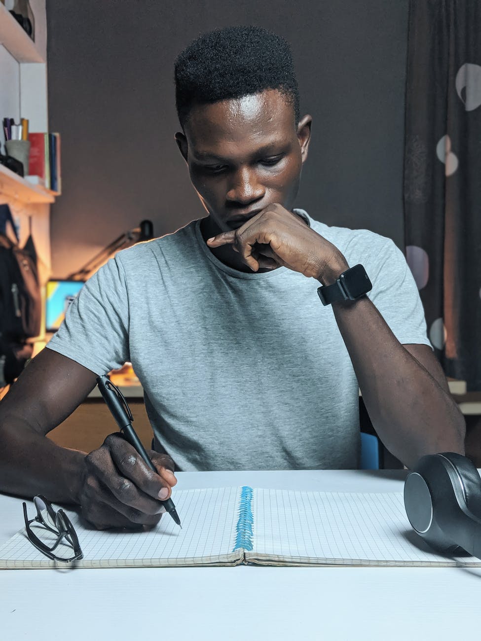 photo of man writing on notebook