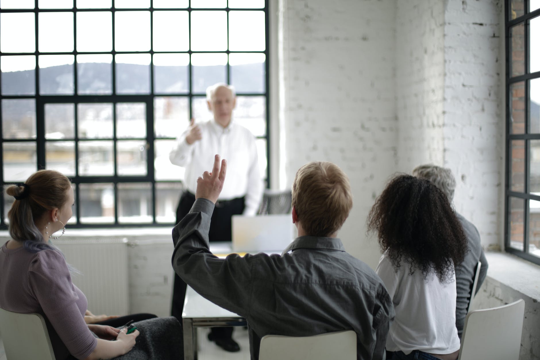 people having a discussion in a white room