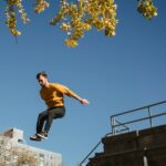 active man jumping from high structure