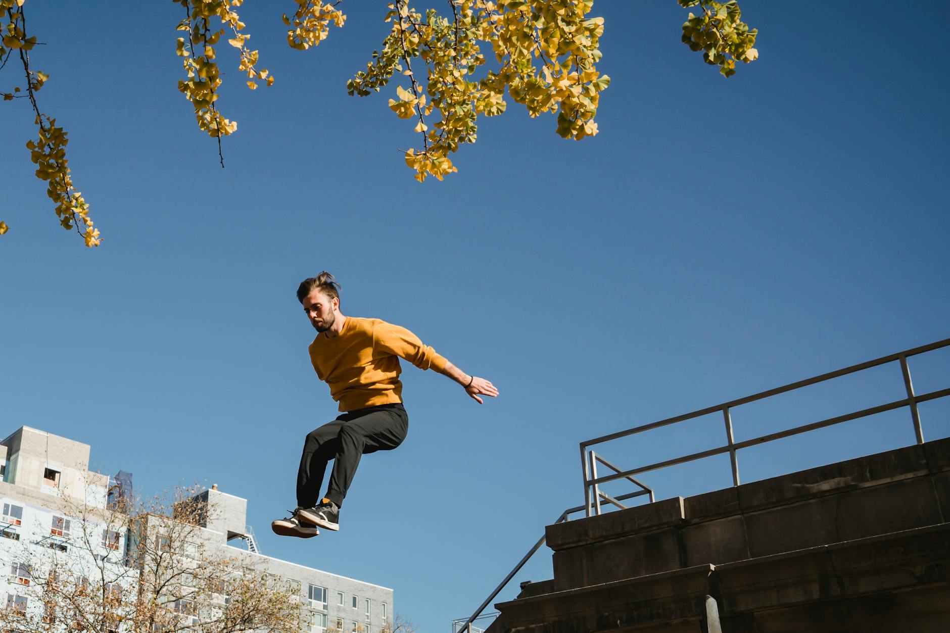 active man jumping from high structure